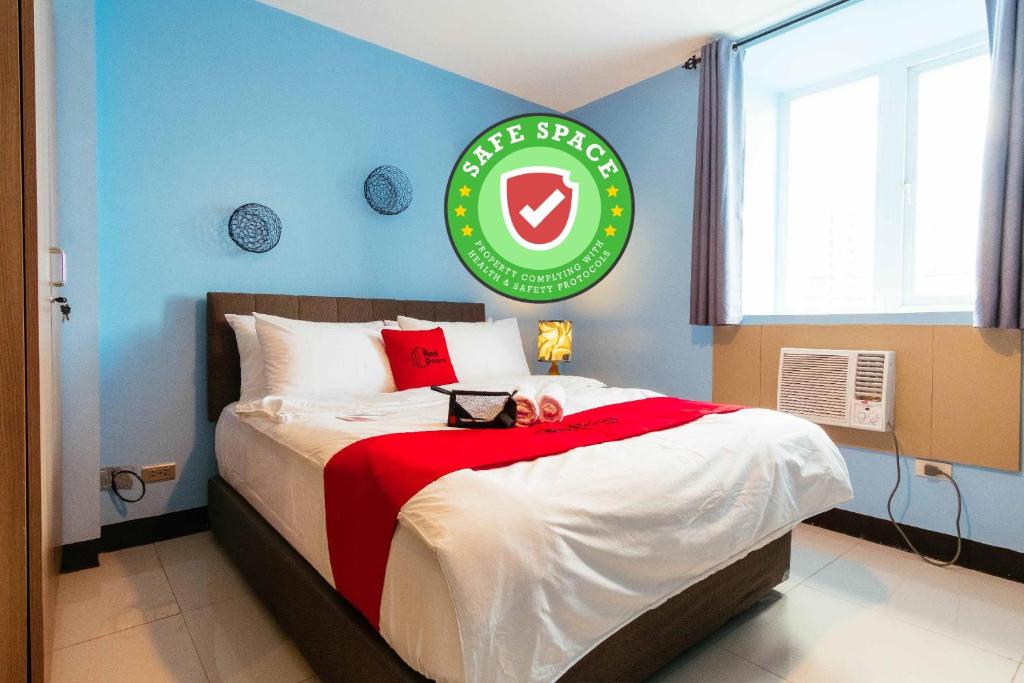 马尼拉RedDoorz Plus @ Kamuning Quezon City的一间卧室配有一张带红白毯子的床