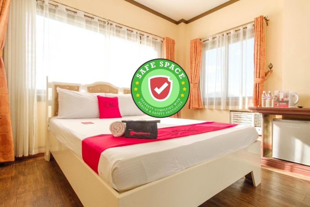 苏比克RedDoorz Plus @ Seaborne Hotel Subic Zambales的一间卧室配有一张大床,上面有标志