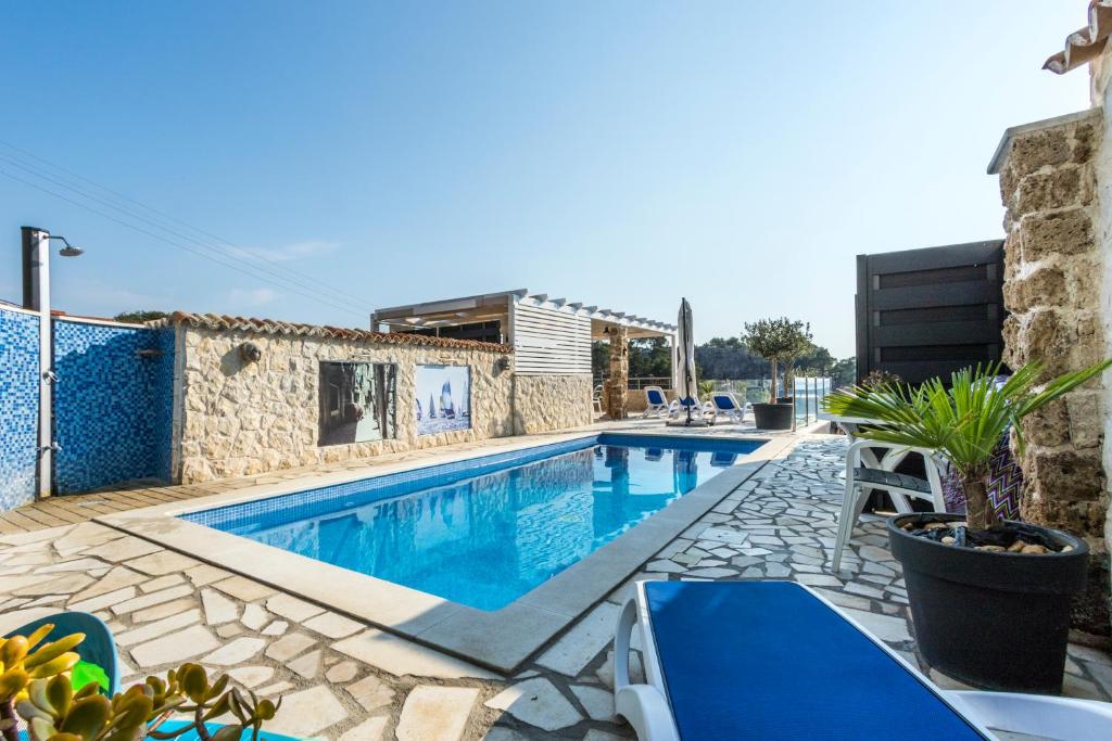 希贝尼克Bluesun Sibenik Apartments的一个带蓝色椅子的游泳池