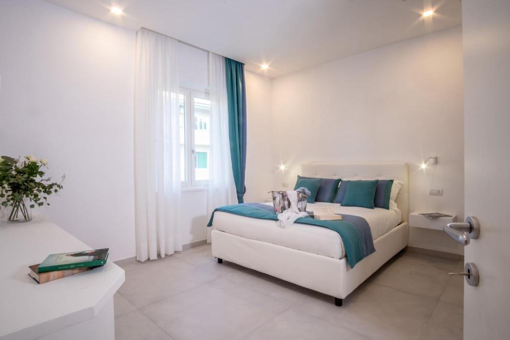 索伦托LEONE ROSSO APARTMENTs的白色的卧室设有床和窗户