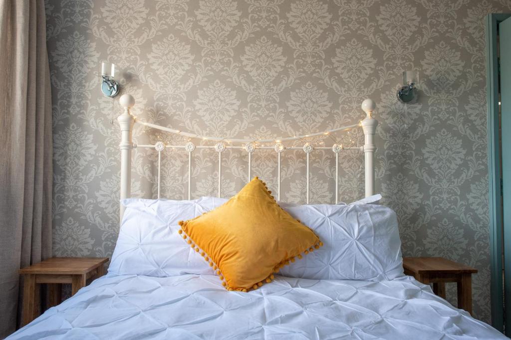 莱姆里吉斯Clovelly Guest House的一张白色的床,上面有黄色枕头