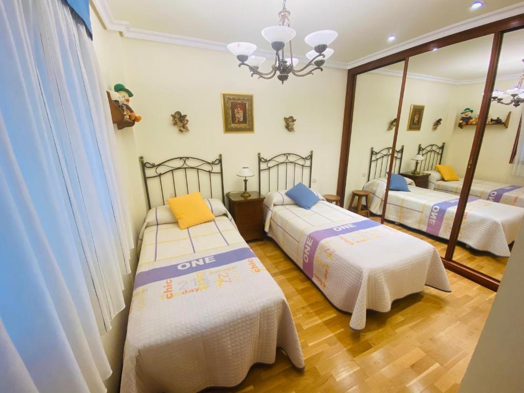 巴约讷Piso Céntrico Baiona的带两张床和镜子的客房