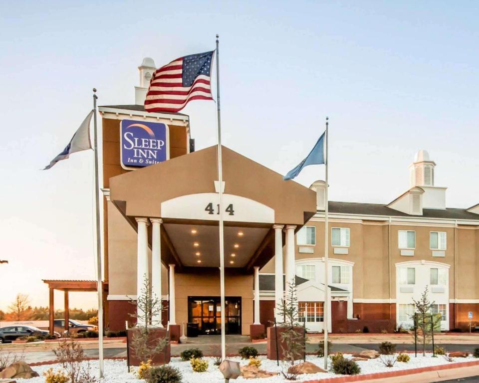 加斯里Sleep Inn & Suites Guthrie - Edmond North的前面有美国国旗的酒店