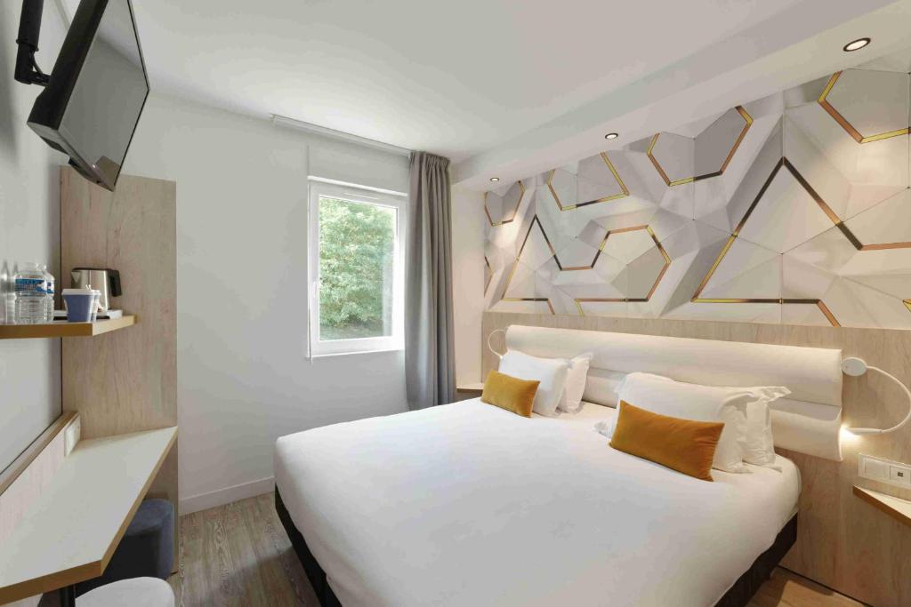 瓦卢瓦地区克雷皮Kyriad Crepy En Valois的卧室配有一张白色大床和电视。