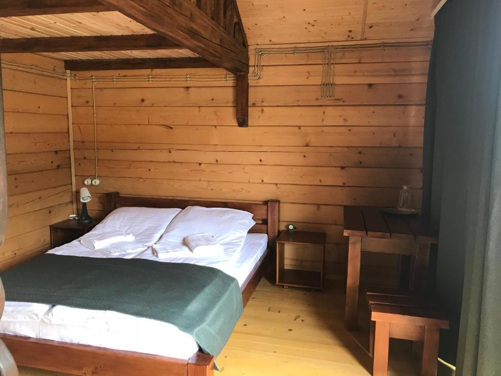 萨塔尼夫Готельний комплекс БУДИНОК РИБАКА的小木屋内一间卧室,配有一张床
