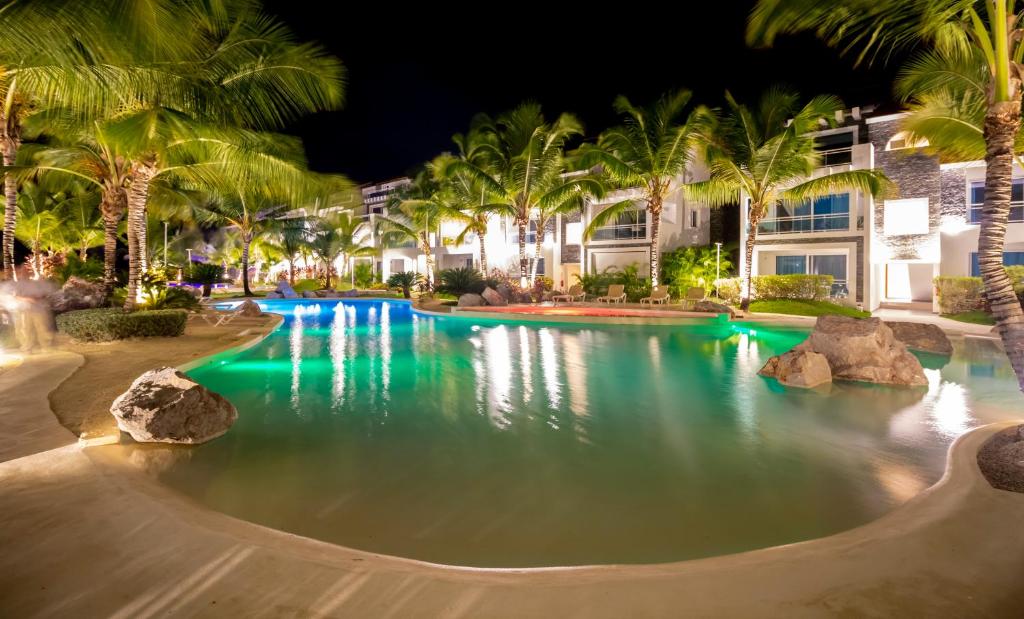 拉古纳Apartamento Estrella Dominicus的棕榈树和建筑的夜间游泳池