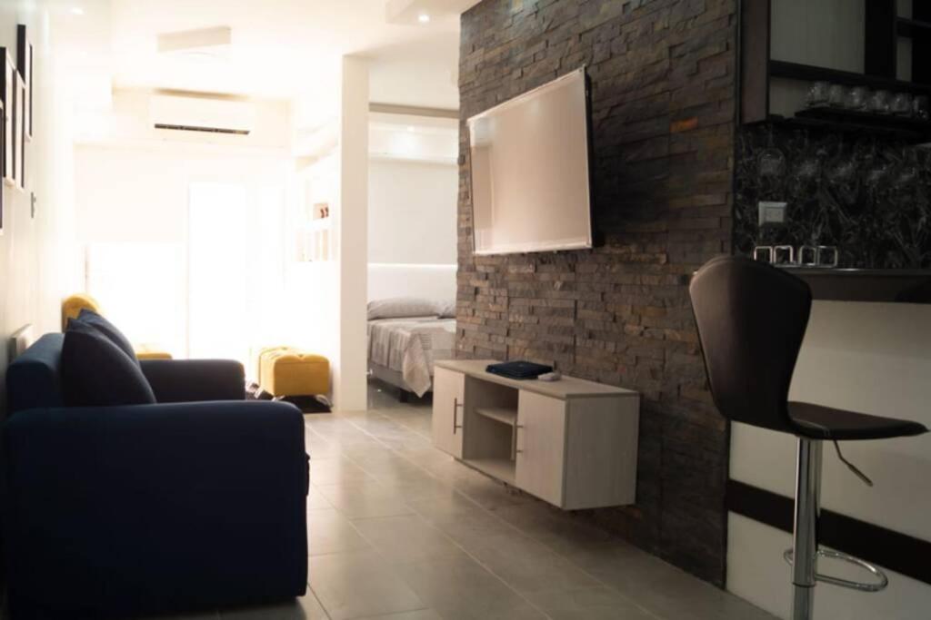 瓜亚基尔Remodeled Studio Apt in Guayaquil Centro w a View的客厅配有黑椅和床。