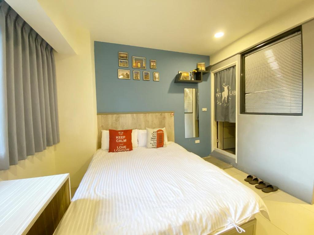 台中市日日逢甲的一间卧室配有带白色床单和橙色枕头的床。