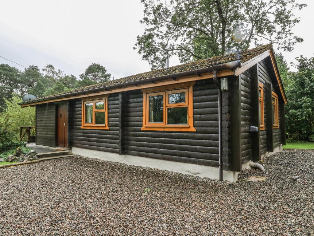 基林Millmore Cabin的小木屋设有橙色窗户和砾石