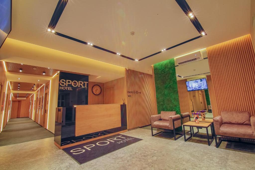 切尔卡瑟Sport Hotel的商店大厅,有两把椅子和一个标牌,上面写着点