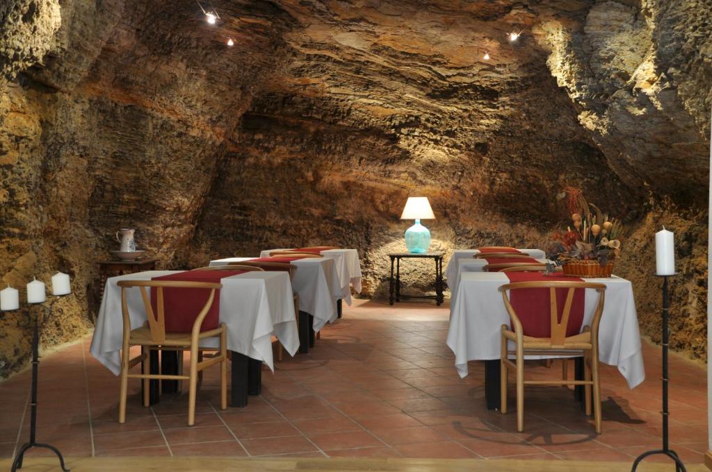 Cervera del Río AlhamaHotel Cervaria的洞穴中的一间用餐室,配有桌椅