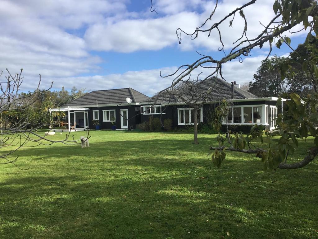 凯里凯里Pa Road B&B Kerikeri NZ的前面有一座绿色庭院的房子