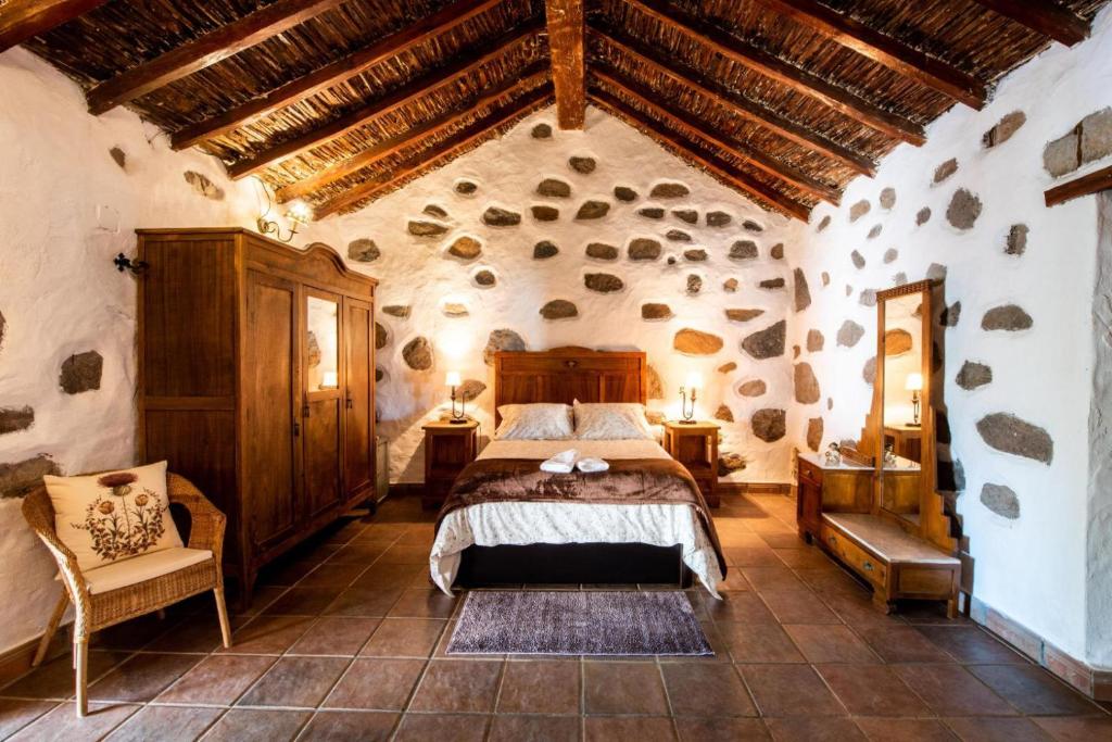 圣巴托洛梅Vv El Lagar de Tunte Fibra Internet的石屋设有一间带大床的卧室