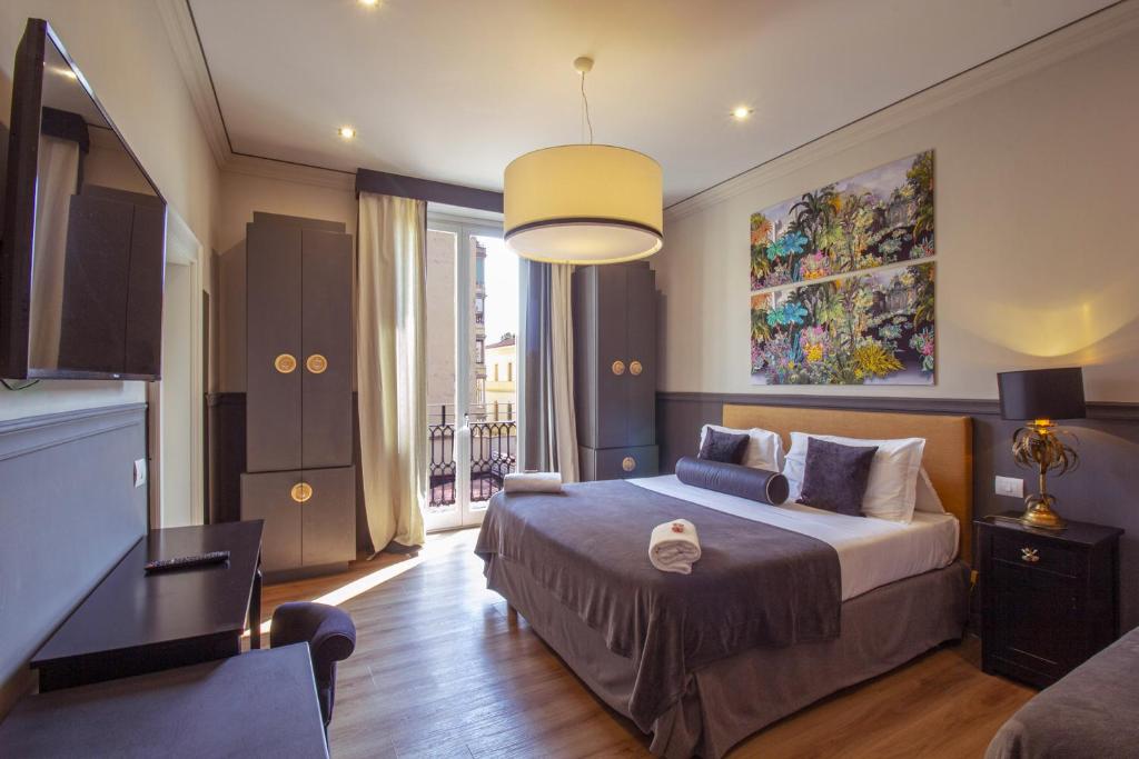 佛罗伦萨雨果精品酒店的一间卧室设有一张大床和一个大窗户