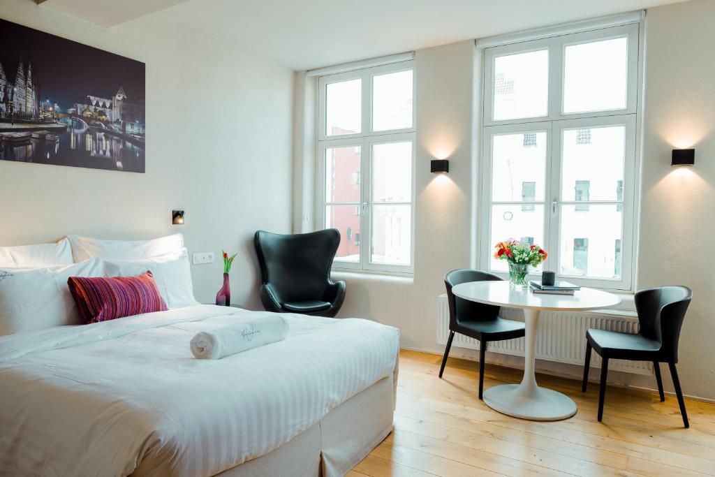 根特Heirloom Hotels - The House of Edward的卧室配有一张床和一张桌子及椅子