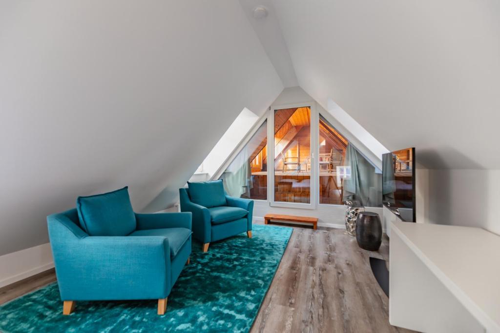 杜伦斯坦Smile Apartments zum Goldenen Strauß的客厅配有2把蓝色椅子和地毯