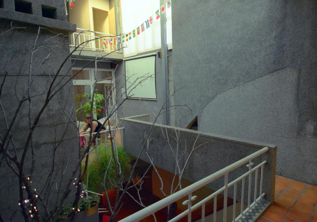 台北Happy Taipei Hostel - Share House - Monthly的站在建筑物阳台的人