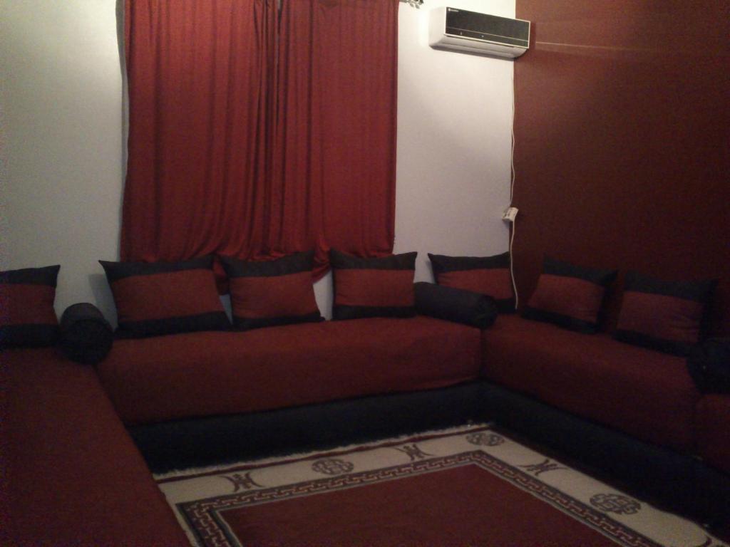 萨伊迪耶Magnifique Appartement Plage Saidia的客厅,窗户前设有红色沙发