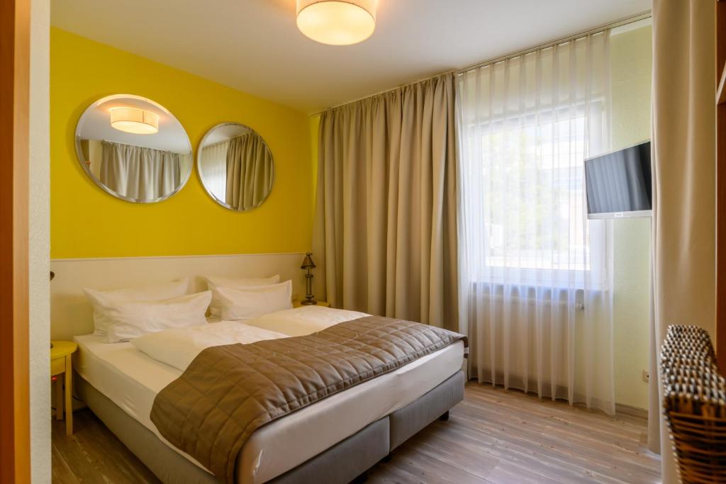 科隆科劳肯伽斯酒店的一间卧室配有一张带黄色墙壁和镜子的床