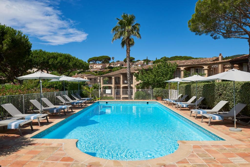 圣马克西姆卡利迪努斯地区酒店的一个带躺椅和遮阳伞的游泳池