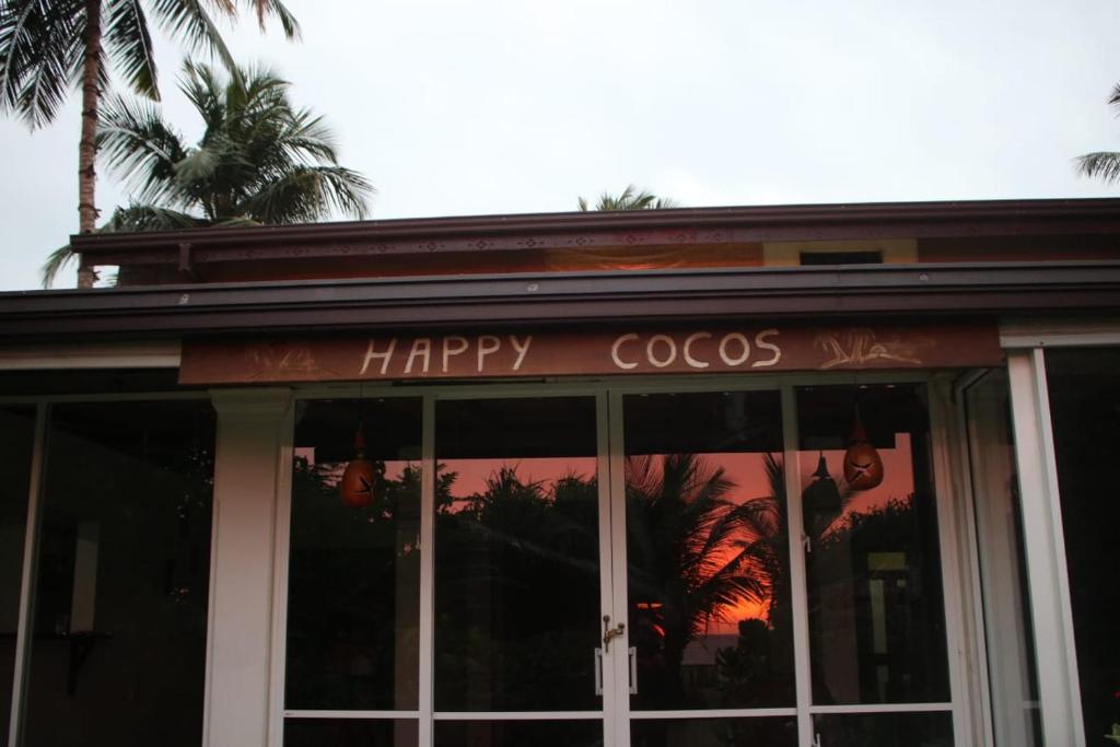 瓦斯卡杜瓦Happy Cocos Beach House的餐厅前方的快乐可可标志