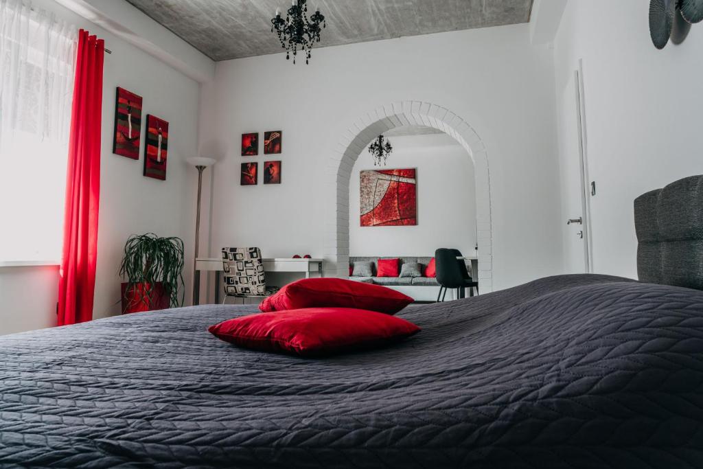 卢布尔雅那Lora & Lana Resort的一间卧室配有一张带红色枕头的床