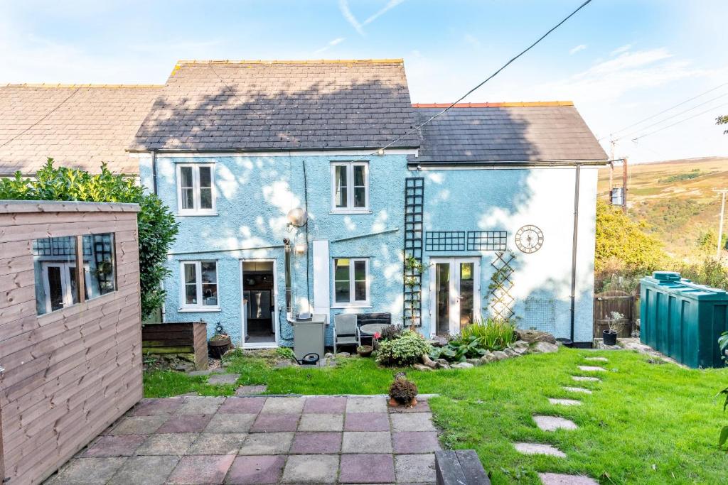 ClydachFinest Retreats - Brecon View Cottage的蓝色和白色的房子,有院子