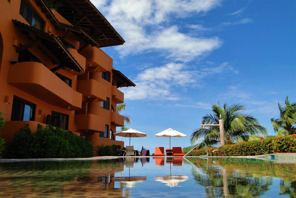 锡瓦塔塔内霍Hotel la Quinta de Don Andres的游泳池位于带遮阳伞的大楼旁