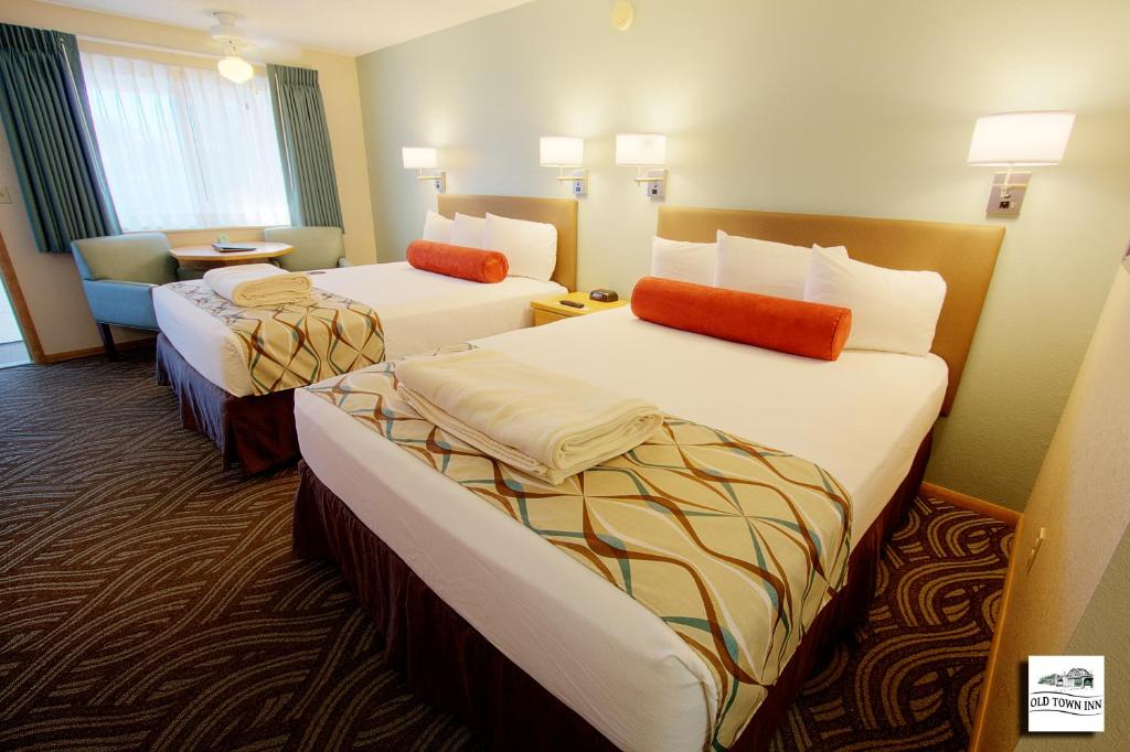 弗洛伦斯古城汽车旅馆的酒店客房,配有两张床和椅子