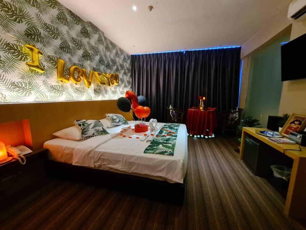 马六甲Grandeur Hotel And Spa的一间卧室配有一张带气球的床。