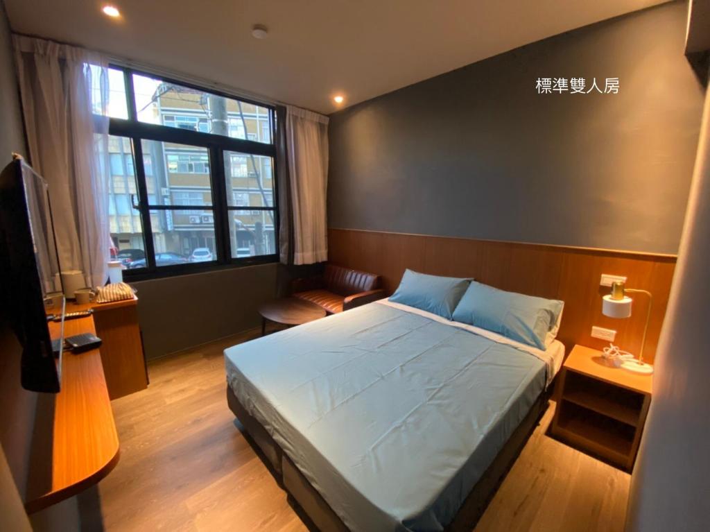 台南良文旅2館Ryou Hotel Vintage - II的一间卧室设有一张床和一个大窗户