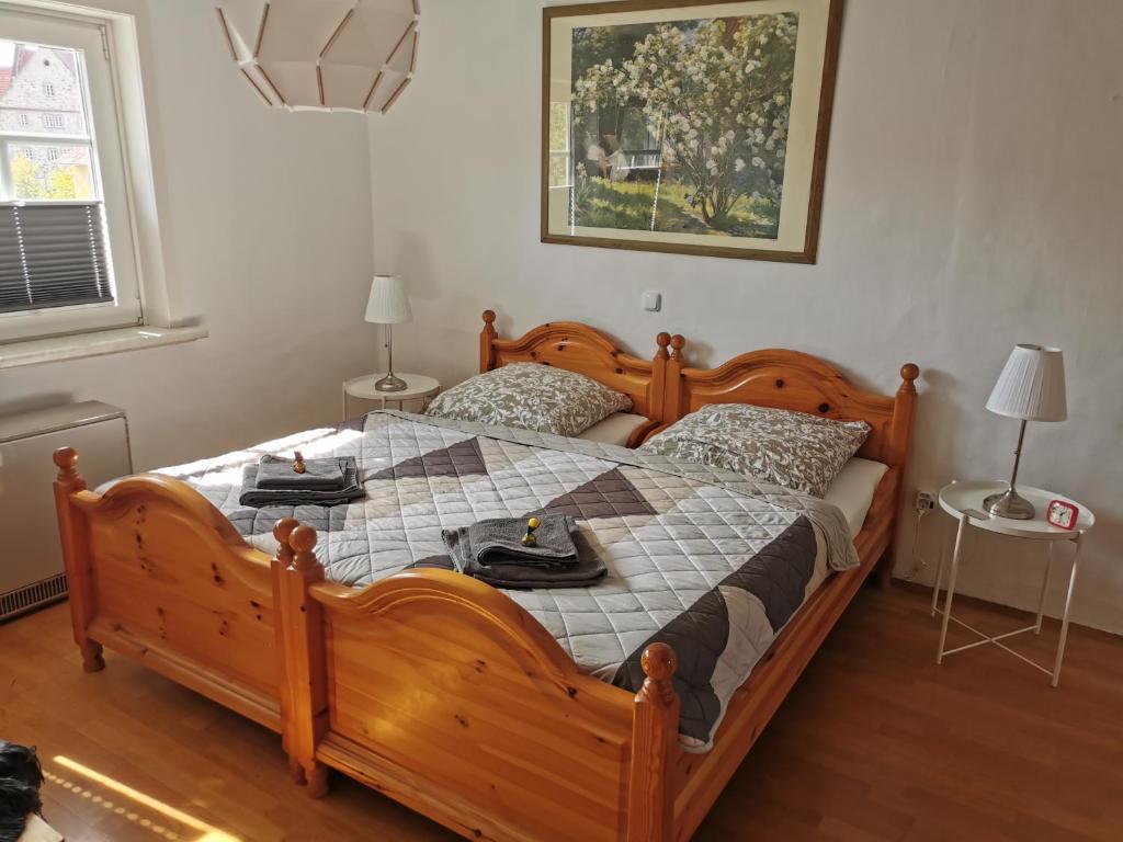 MorschenGästehaus Domänenblick的一间卧室配有一张带两张桌子的大型木床