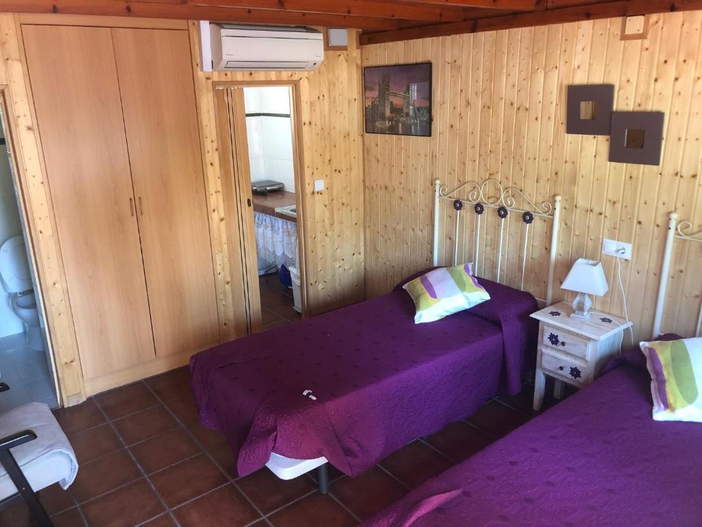 多列毛利诺斯多列毛利诺斯露营旅馆的一间卧室配有一张紫色的床和镜子