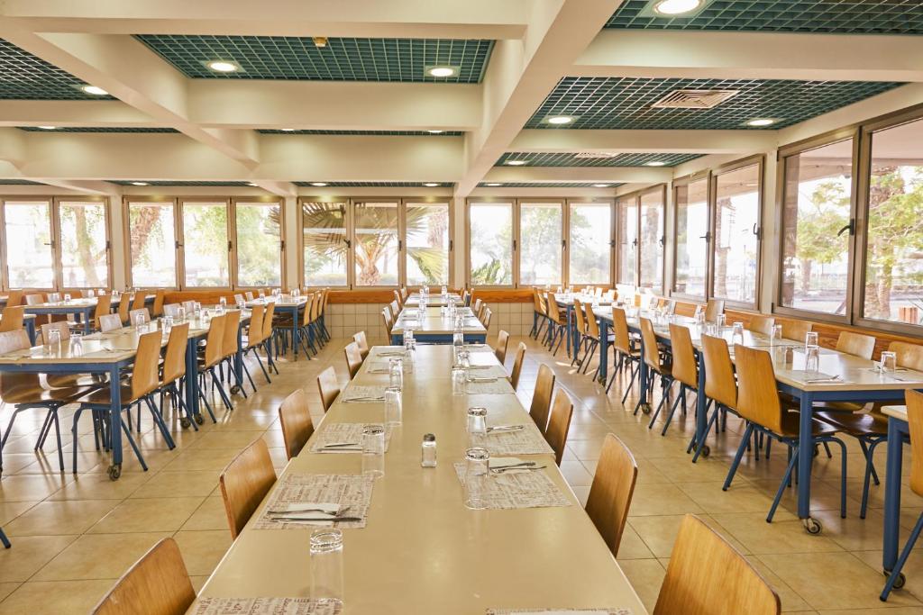 埃拉特SPNI Eilat Field School的有桌椅和窗户的餐厅