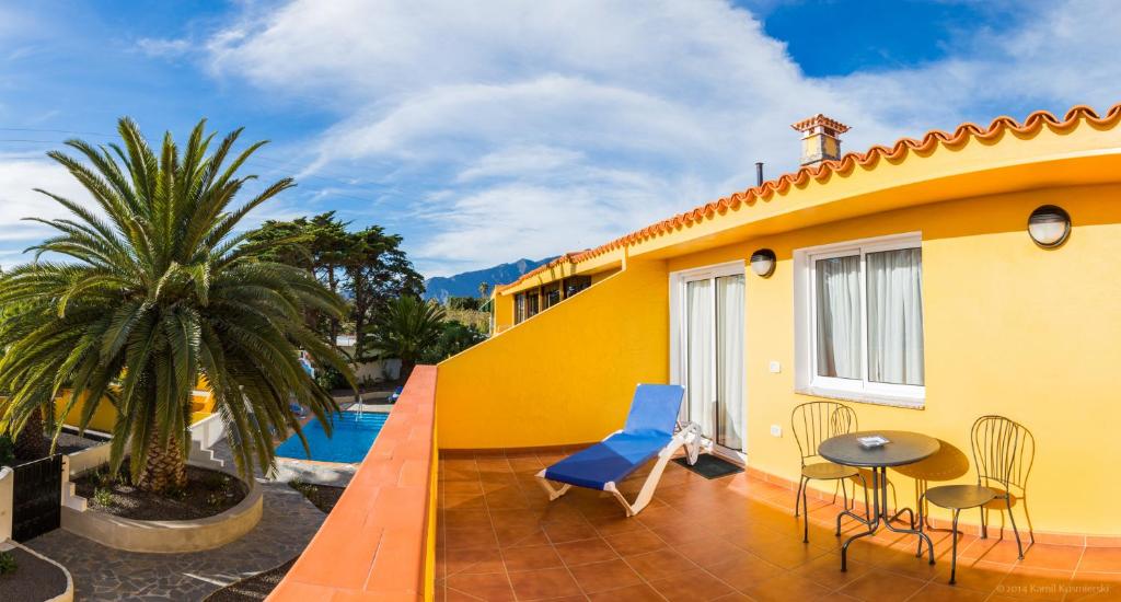 洛斯·亚诺斯·德·阿里丹Apartamentos Villa María的黄色的房屋设有带桌椅的庭院