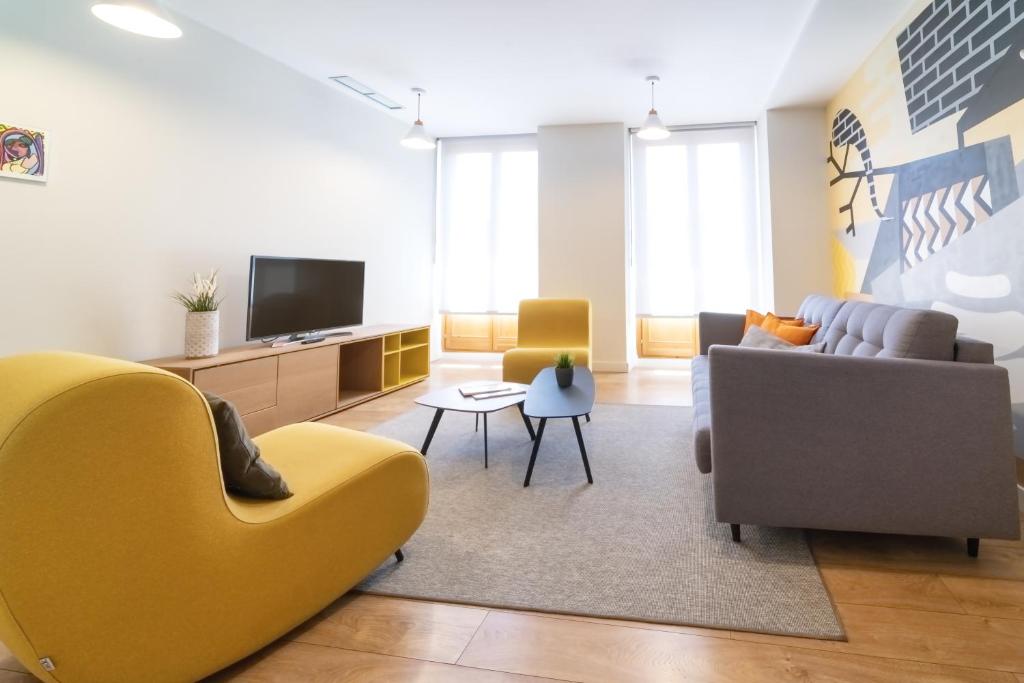 马德里Morar Apartments Malasaña的带沙发和电视的客厅