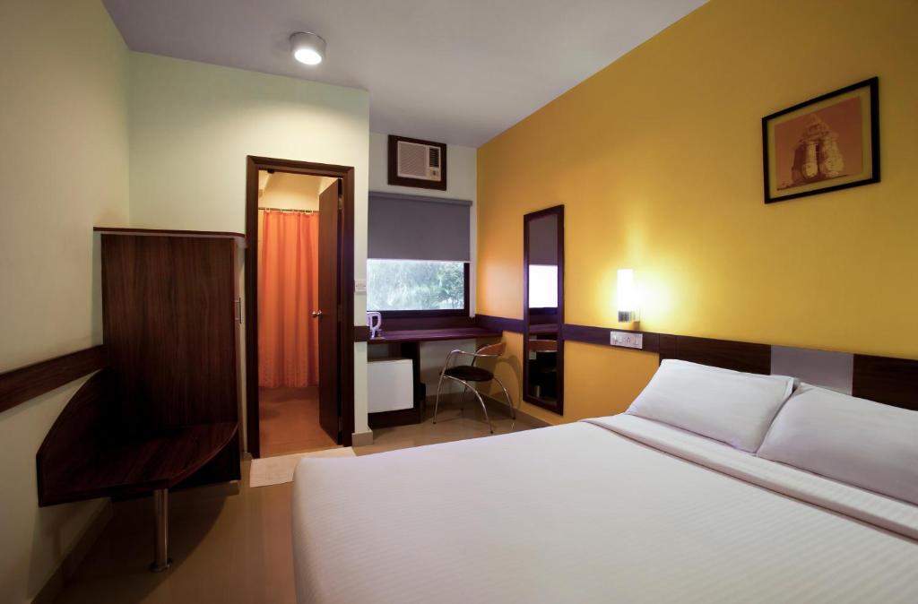 古瓦哈提格尔瓦哈提酒店的一间卧室配有一张床、一张桌子和一把椅子
