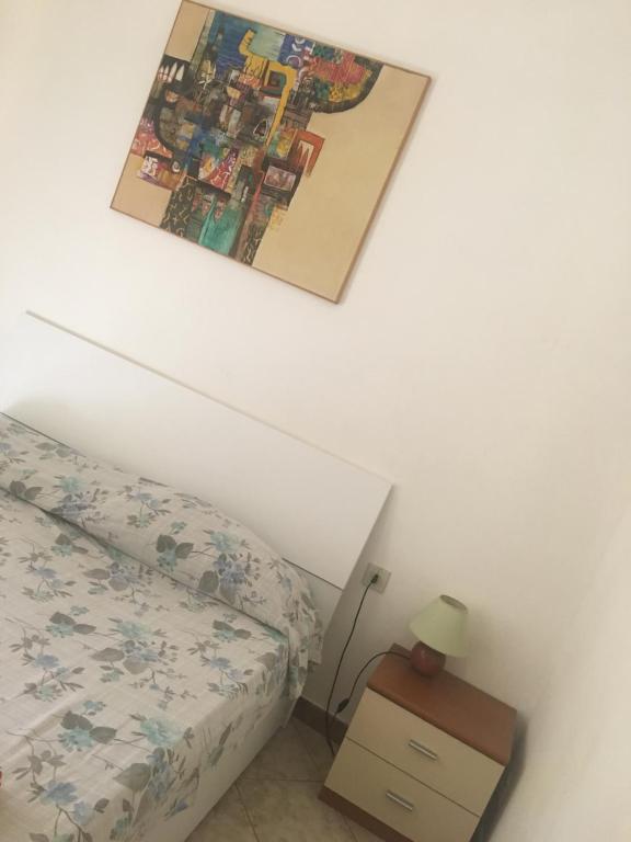巴勒莫安蒂卡萨托瑞公寓的卧室配有一张床,墙上挂着一幅画