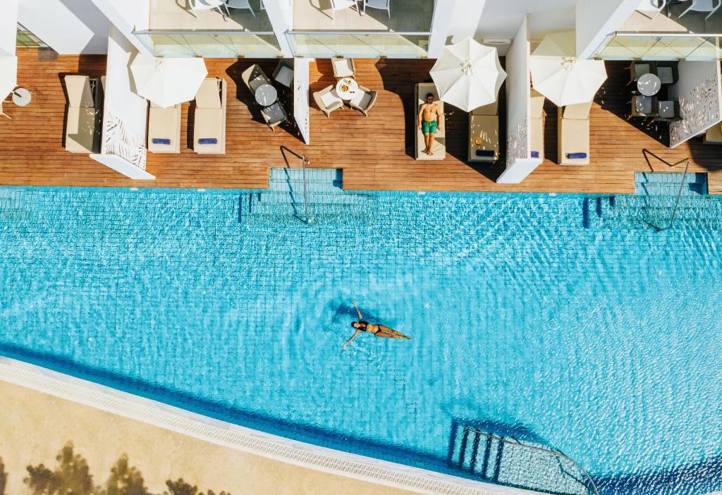 帕福斯Sofianna Resort & Spa的在大型游泳池游泳的人
