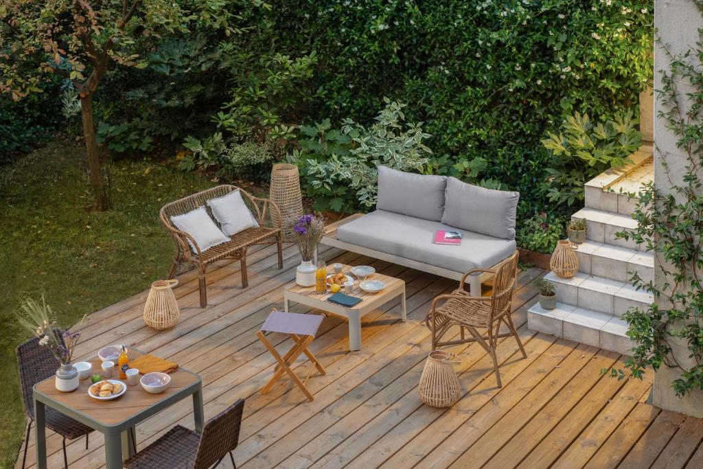 巴黎PEPPER & PAPER Apartments的木制甲板配有椅子、沙发和桌子