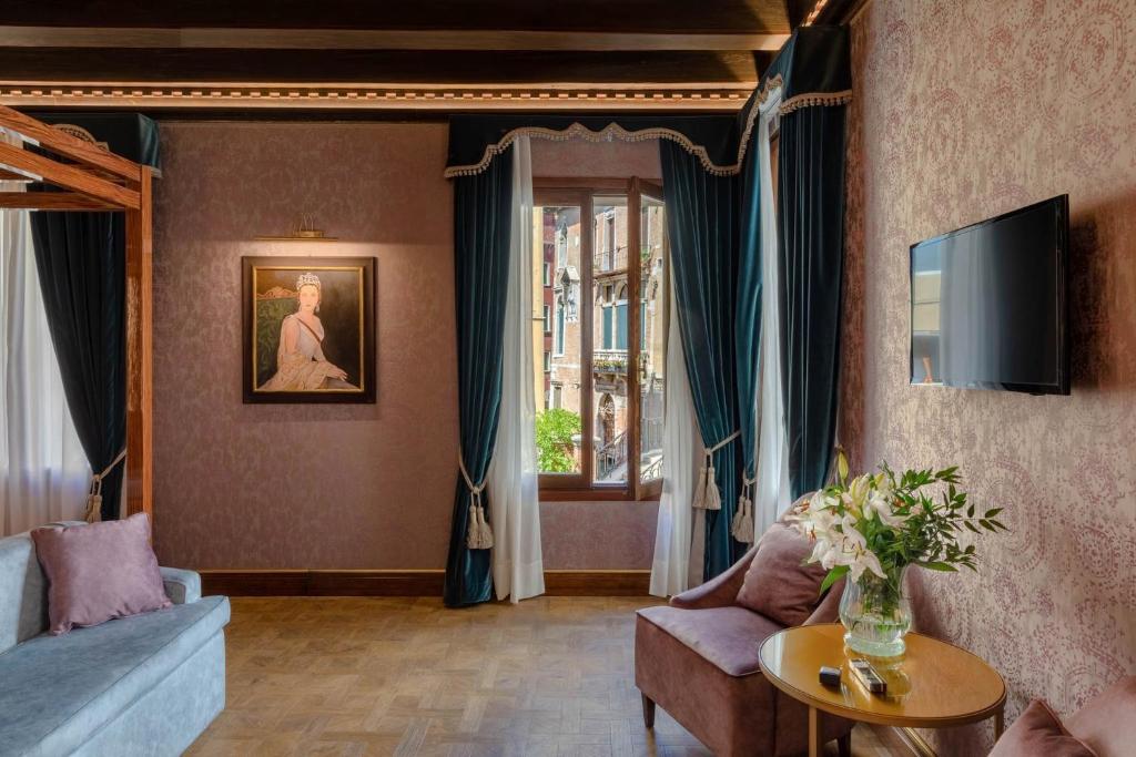 威尼斯多纳宫酒店的客厅配有沙发和桌子