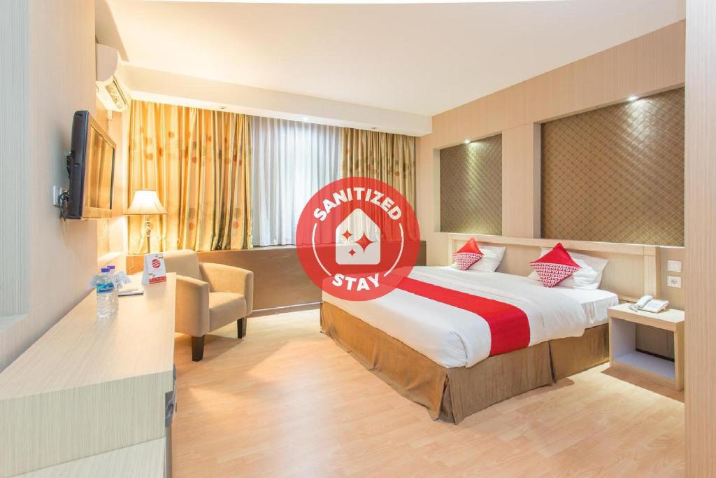 巴厘巴板Super OYO 663 Hotel Sejati的酒店客房的床铺上标有红色的标志