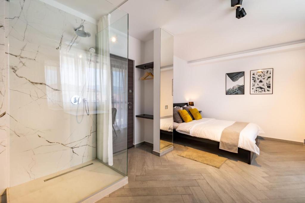 克卢日-纳波卡Urbio Private Suites的一间卧室设有一张床和一个玻璃淋浴间