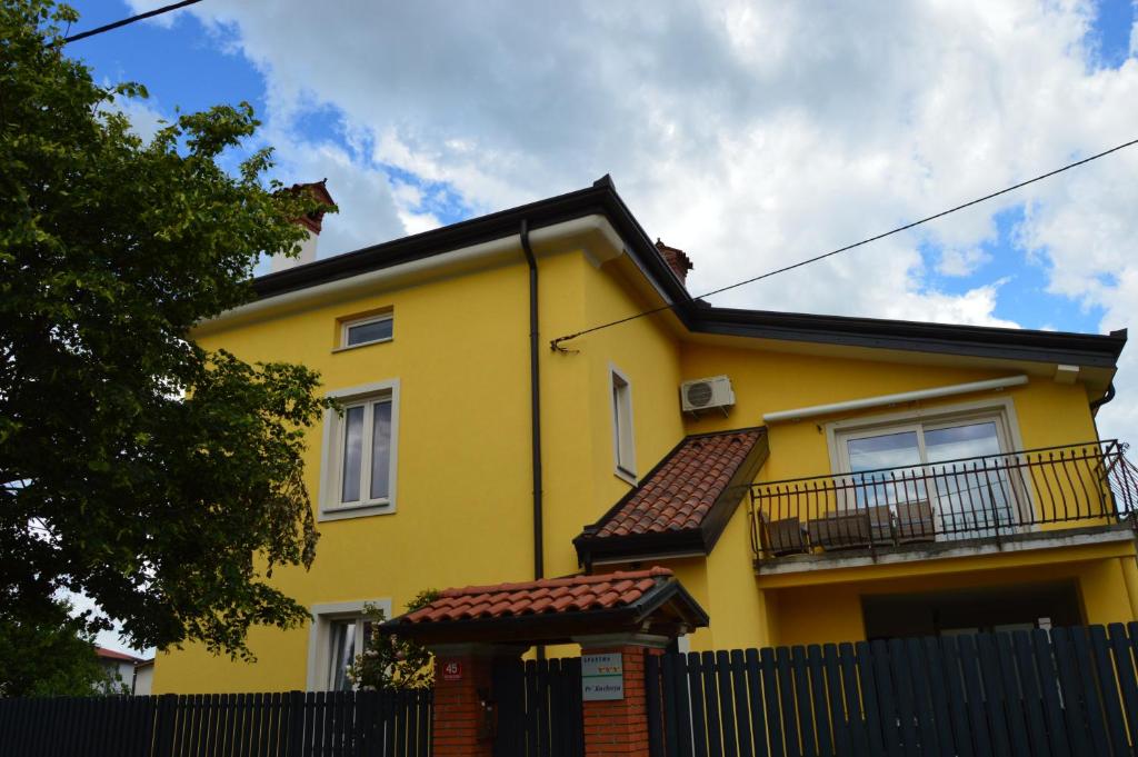 新戈里察Apartment Kancler的前面有栅栏的黄色房子