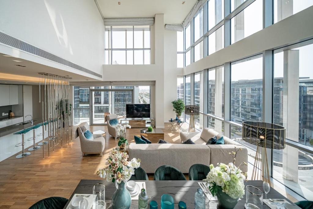 迪拜HiGuests - Stunning Family Size Apt with Panoramic Views的一个大客厅,有很多窗户