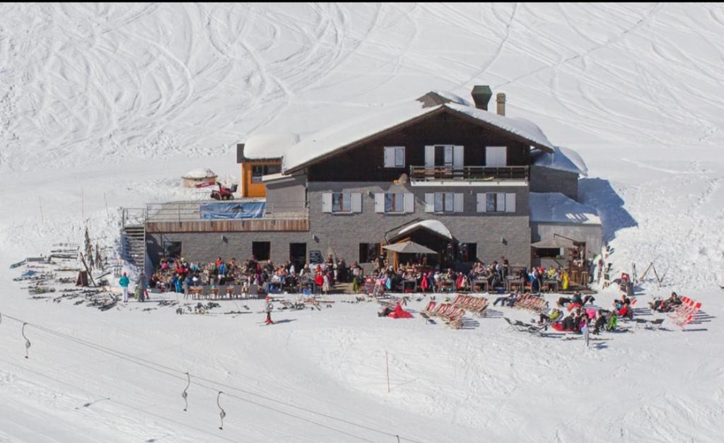 雷克罗塞Refuge Le Marcheuson的一群人坐在滑雪小屋外面