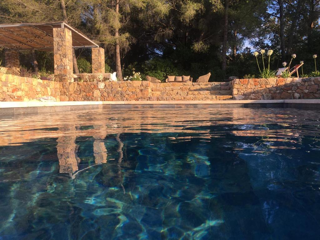 滨海萨纳里Bastide Sainte Trinide的蓝色海水和石墙的游泳池