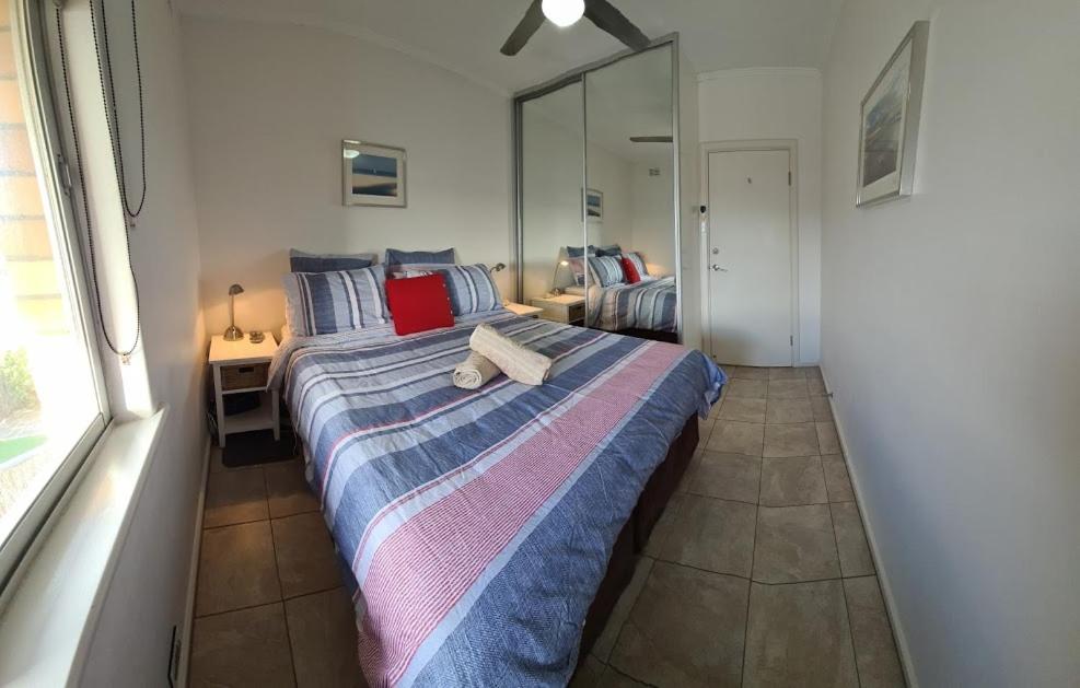 阿德莱德Acushla Accommodation Esplanade Living Self Check-In Self Check-Out的一间卧室设有一张床和一个大窗户