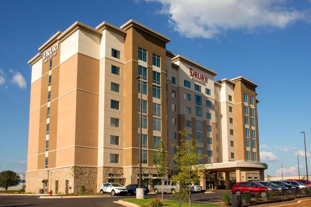 亨茨维尔Drury Inn & Suites Huntsville Space & Rocket Center的停车场内停放汽车的酒店大楼