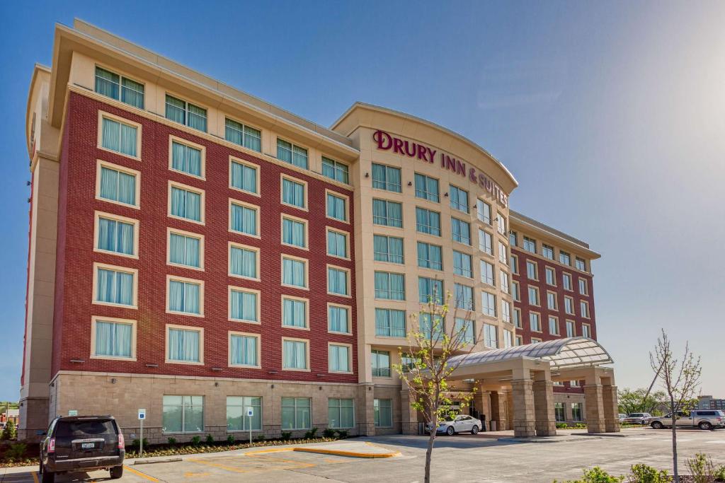 克拉尔维尔Drury Inn & Suites Iowa City Coralville的一座拥有红色建筑的酒店,设有停车场